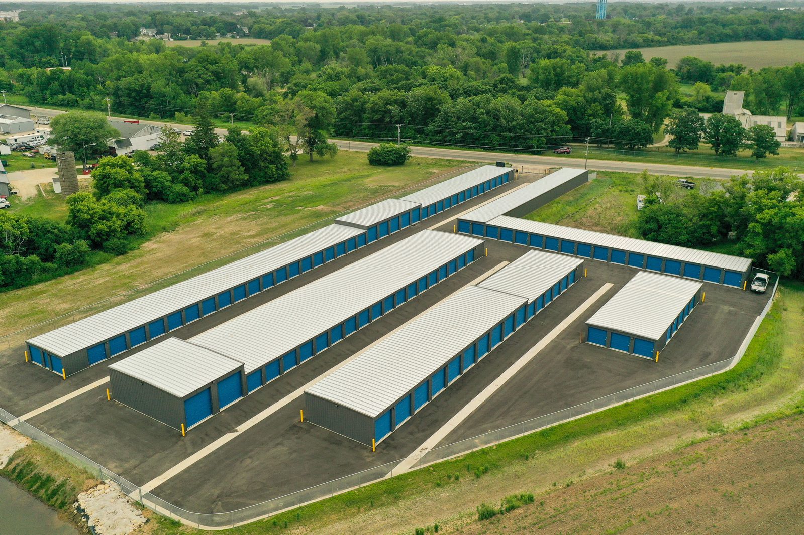 Aerial view of a completed multi-building drive-up self-storage complex with blue roll-up doors